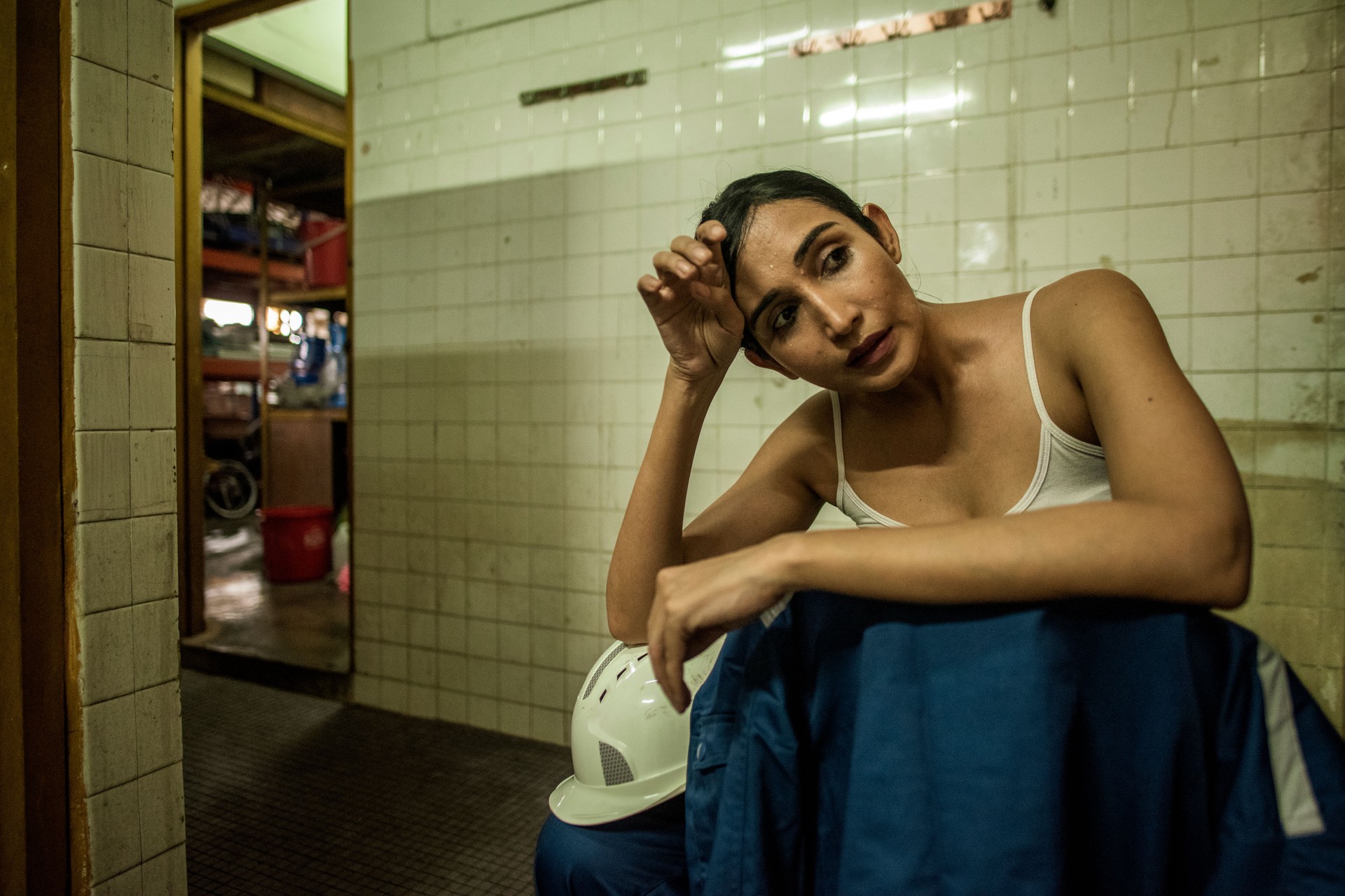Exhausted Indian Female factory worker in toilet resting