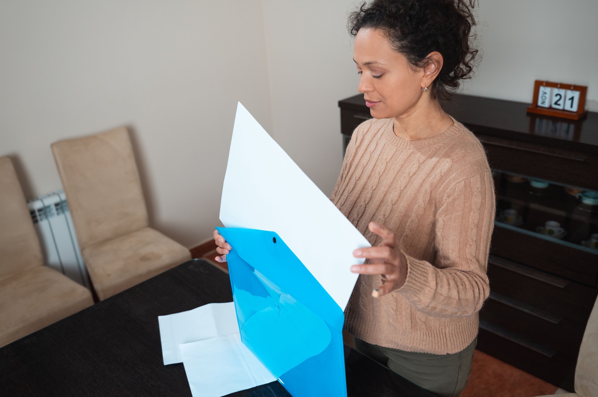 Woman organizing documents in a bright and welcoming home office setting